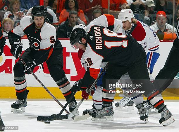 Mike Richards and Braydon Coburn of the Philadelphia Flyers battle for the puck against the Montreal Canadiens during Game 4 of the Eastern...