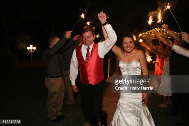 bride and groom walking under row of sparklers, as their exit to their wedding - first night of marriage stock pictures, royalty-free photos & images
