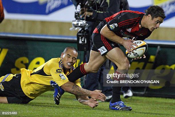 Canterbury Crusaders Dan Carter slips a tackle from Wellington Hurricanes Hosea Gear in their Super 14 rugby semi-final match at AMI Stadium in...