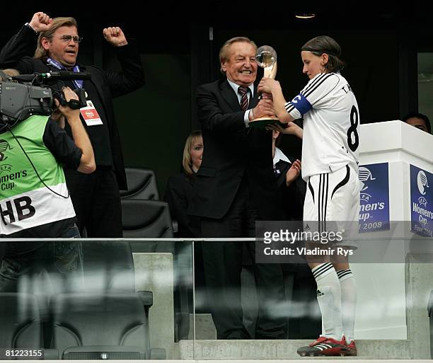 Tina Wunderlich of Frankfurt takes over the trophy from the UEFA Vice President Gerhard Mayer-Vorfelder as coach Hans-Juergen Tritschoks celebrates...