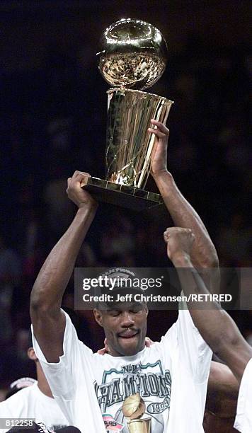 San Antonio Spurs'' David Robinson looks down as he holds the NBA Championship trophy after the Spurs 78-77 win in the NBA Finals over the New York...