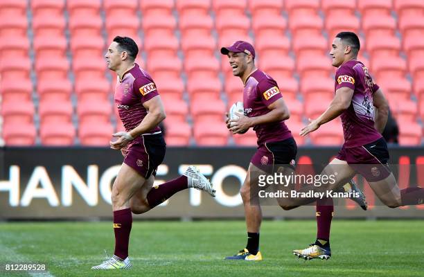Billy Slater is seen running with team mates Will Chambers and Valentine Holmes during a Queensland Maroons State of Origin training session at...