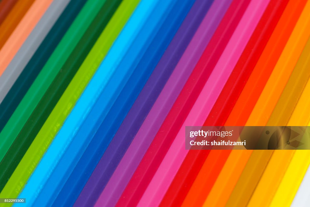 Selective focus of pencil colours on near-white chopping board