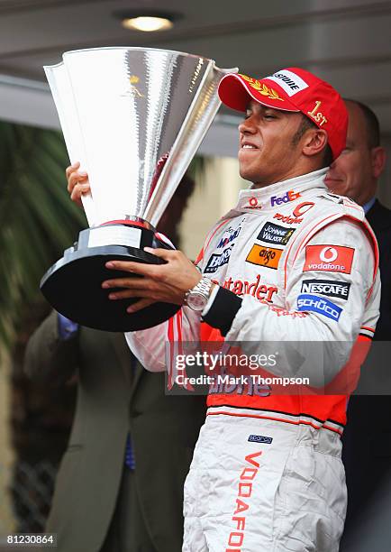 Lewis Hamilton of Great Britain and McLaren Mercedes celebrates on the podium after being presented with the winners trophy by Prince Albert II of...
