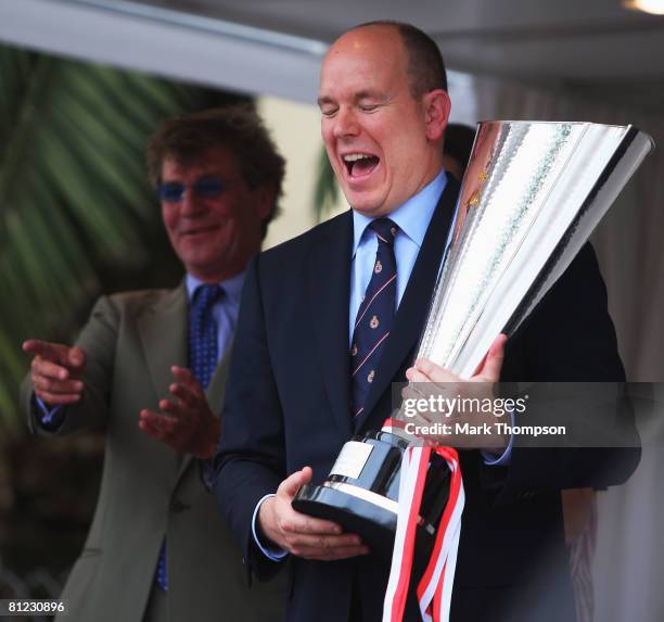 Prince Albert II of Monaco shares a joke with Lewis Hamilton of Great Britain and McLaren Mercedes as he presents him with the winners trophy...