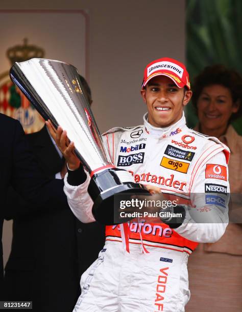 Lewis Hamilton of Great Britain and McLaren Mercedes celebrates on the podium after being presented with the winners trophy by Prince Albert II of...