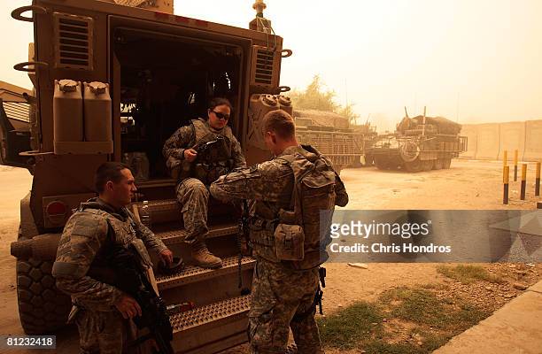 Soldiers of the 3rd Brigade Combat Team of the 4th Infantry Division assemble behind their MRAP vehicle before heading out on patrol during a...