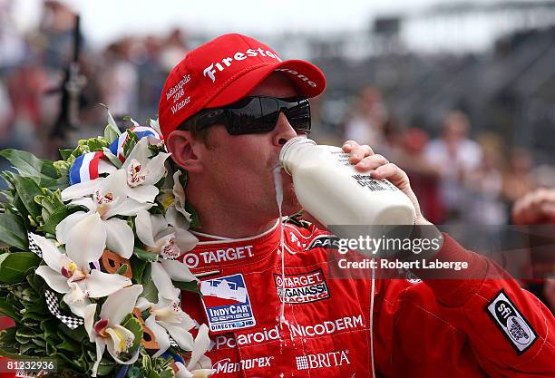 Scott Dixon, driver of the Target Chip Ganassi Racing Dallara Honda, drinks the ceremonial winner's milk over in victory lane in celebration of...