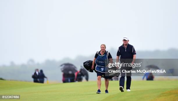 David Drysdale of Scotland makes his along the 18th fairway with his wife and caddy Vicky Drysdale during the final round at the Dubai Duty Free...