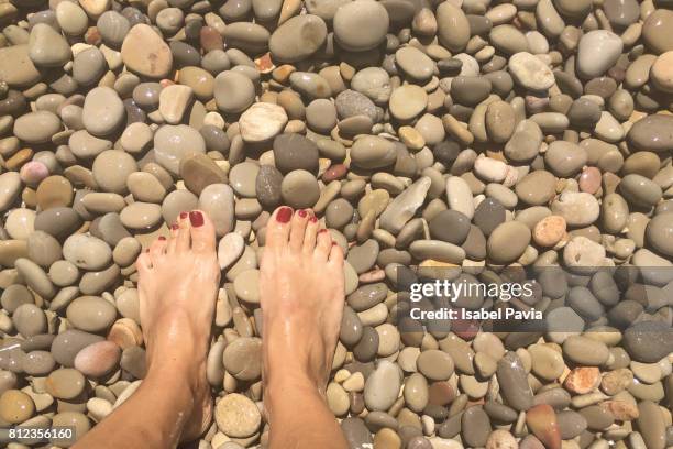 low section of woman feet on pebbles at beach - pebble island stock pictures, royalty-free photos & images