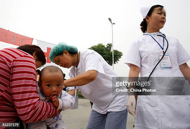 Doctors inspect an injured earthquake survivor at the field hospital newly built by German Red Cross for China's earthquake victims on May 26, 2008...