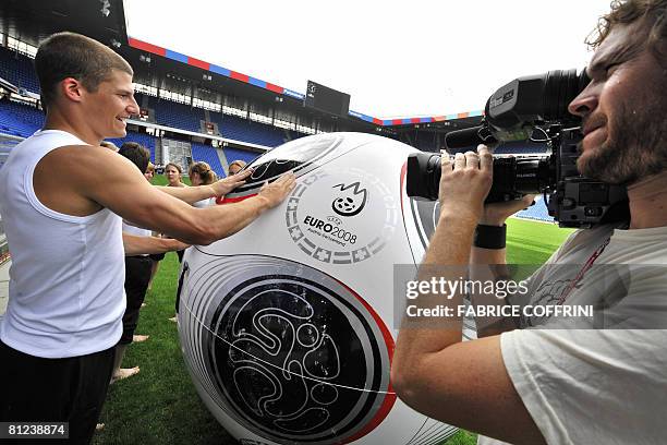 Gymnast touches a giant matchball of the Euro 2008 during a pratice session of the EURO 2008 pre-match ceremony at the St Jakob Park stadium on May...