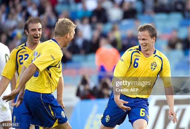 Sweden's Kennedy Bakirciogly and Marcus Allback congratulate team-mate Tobias Linderoth after he scored against Slovenia during their friendly match...