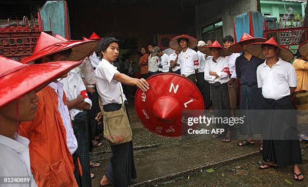 Members of detained opposition leader Aung San Suu Kyi's National League for Democracy Party wait to welcome guests at the party's headquarters to...