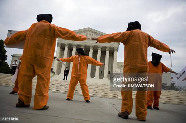 Demonstrators with Witness Against Torture in orange jumpsuits and black hoods prepare to march from the US Supreme Court to the DC Superior Court in...