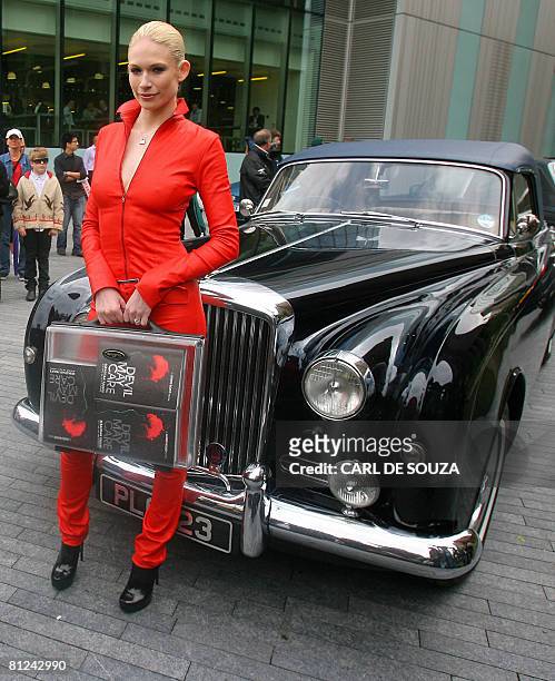Model Tuuli Shipster holds a briefcase containing the first copies of the new James Bond novel entitled 'Devil May Care,' as she poses for pictures...