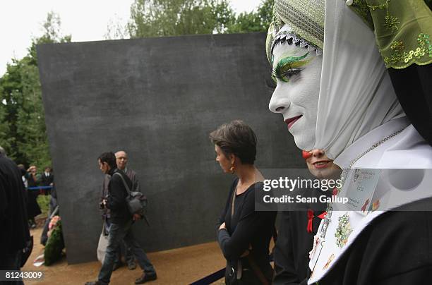 Visitors, including a transvestite, line up to peek into the window of the just-inaugurated memorial to homosexual victims of the Nazis on May 27,...