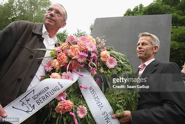 Two men from a gay councilling organization hold a wreath while lining up to peek into the window of the just-inaugurated memorial to homosexual...