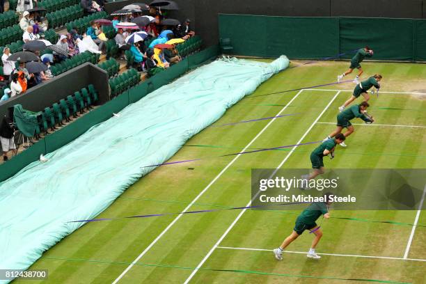 The covers are pulled across court two as rain starts to fall on day eight of the Wimbledon Lawn Tennis Championships at the All England Lawn Tennis...