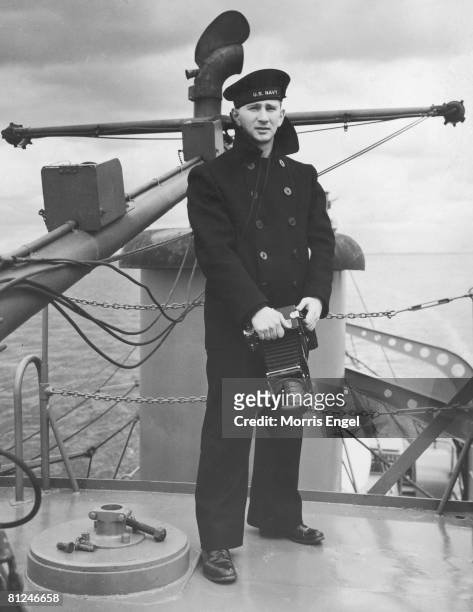 Portrait of American Naval photographer Morris Engel as he poses, camera in hand, on the deck of an unidentiifed ship, mid 1940s. Engel shot footage...