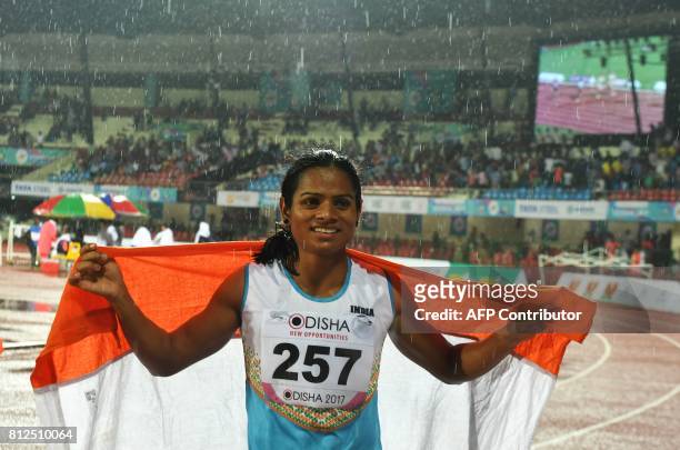 In this photograph taken on July 7 India's Dutee Chand celebrates after placing third in the women's 100m event at the 22nd Asian Athletics...