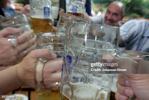 Visitors of the Augustiner beergarden cheer during a warm summer afternoon on May 28, 2008 in Munich, Germany. Visiting beergardens is very popular...