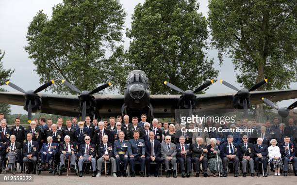 Britain's Prince William, Duke of Cambridge , Patron of the Battle of Britain Memorial Flight, poses for a photograph with veterans at RAF Coningsby...