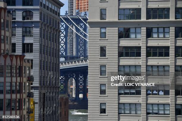 Boat sails under the Manhattan Bridge in Brooklyn, on July 2, 2017 in New York City. / AFP PHOTO / LOIC VENANCE