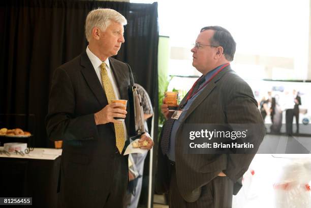 William W. George a director on the ExxonMobil board, talks with Brian Flannery before the ExxonMobil annual shareholders meeting at the Morton H....