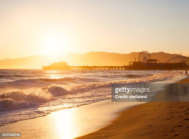 strand von santa monica bei sonnenuntergang - santa monica stock-fotos und bilder