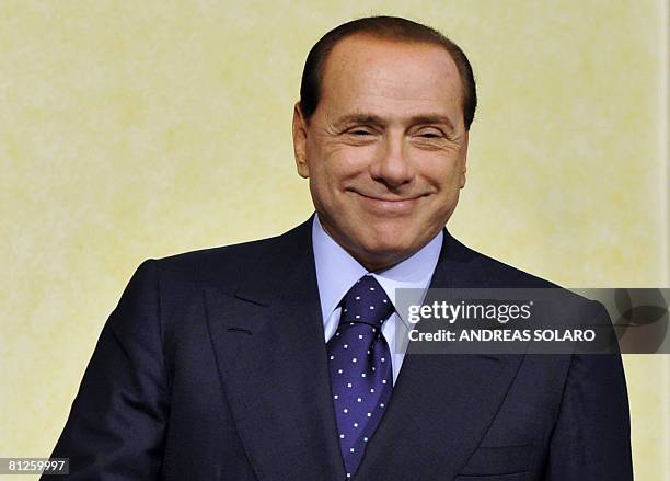 Italian Prime Minister Silvio Berlusconi smiles to photographers as he greets Canadian counterpart Stephen Harper at Chigi Palace in Rome on May 28,...