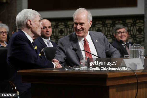 Former Senate Armed Services Committee Chairman and former Secretary of the Navy John Warner shakes hands with Richard Spencer after testifying on...