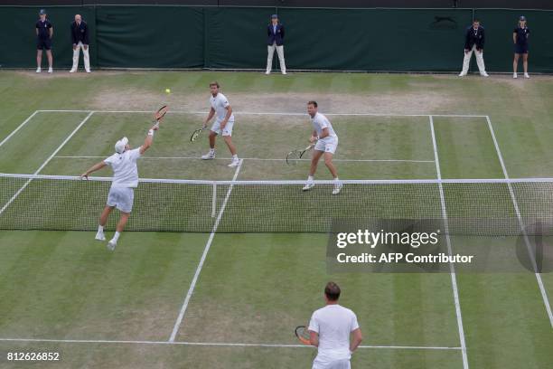 Finland's Henri Kontinen stands by as his partner Australia's John Peers volleys at the net against opponents US player Ryan Harrison and New...