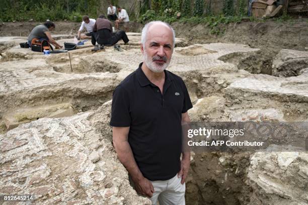 Inrap President Dominique Garcia poses as archaeologists from Inrap excavate mosaics at an archaeological site from the Gallo-Roman era, on July 11,...