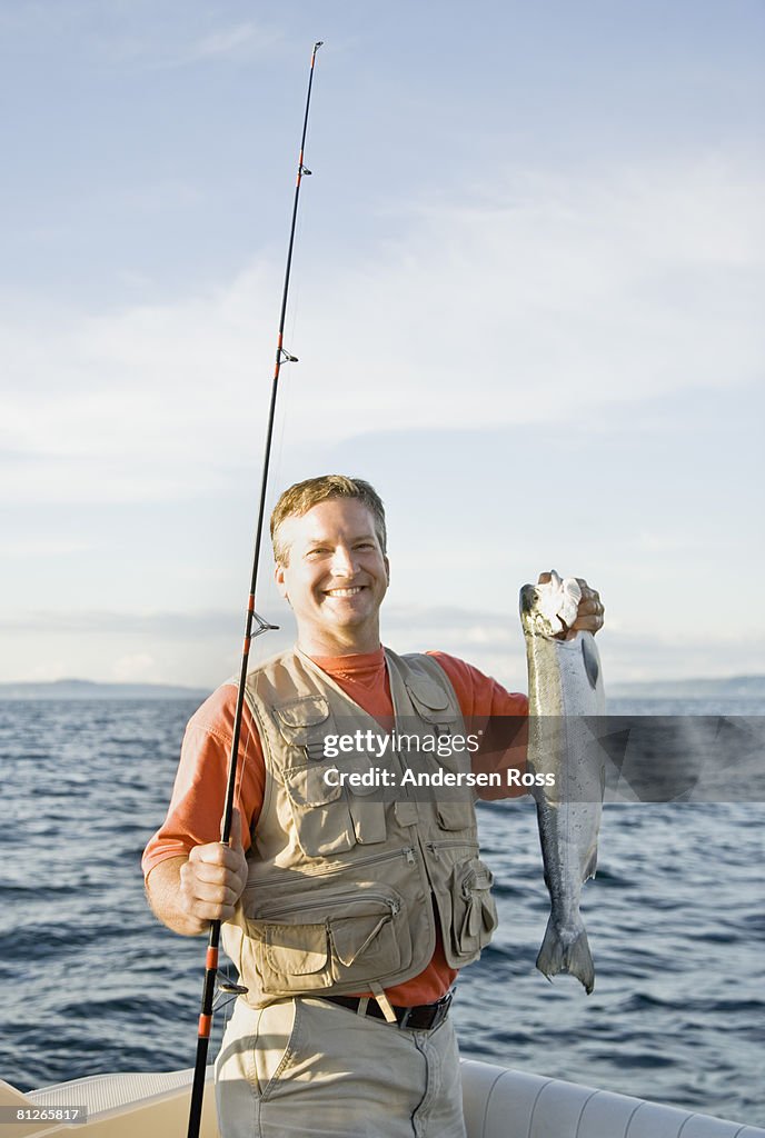 Man On Boat With Fishing Pole And Fish High-Res Stock Photo