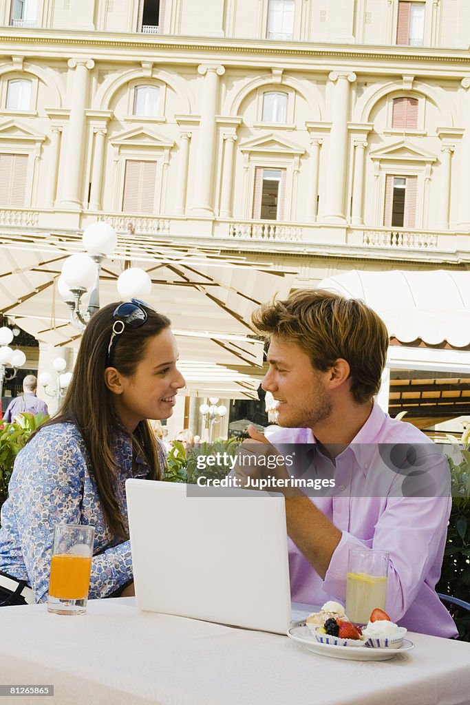 Face to face couple with laptop computer