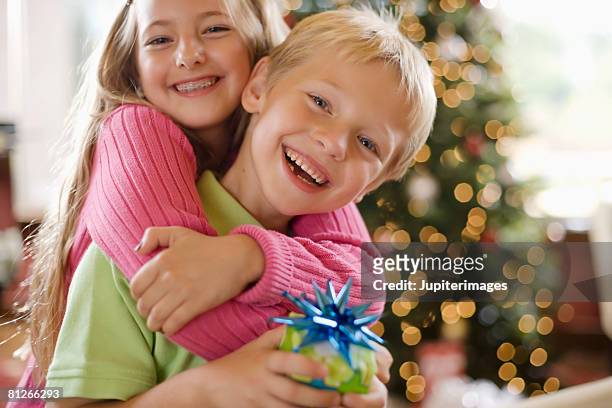 siblings at christmas - sibling christmas stock pictures, royalty-free photos & images