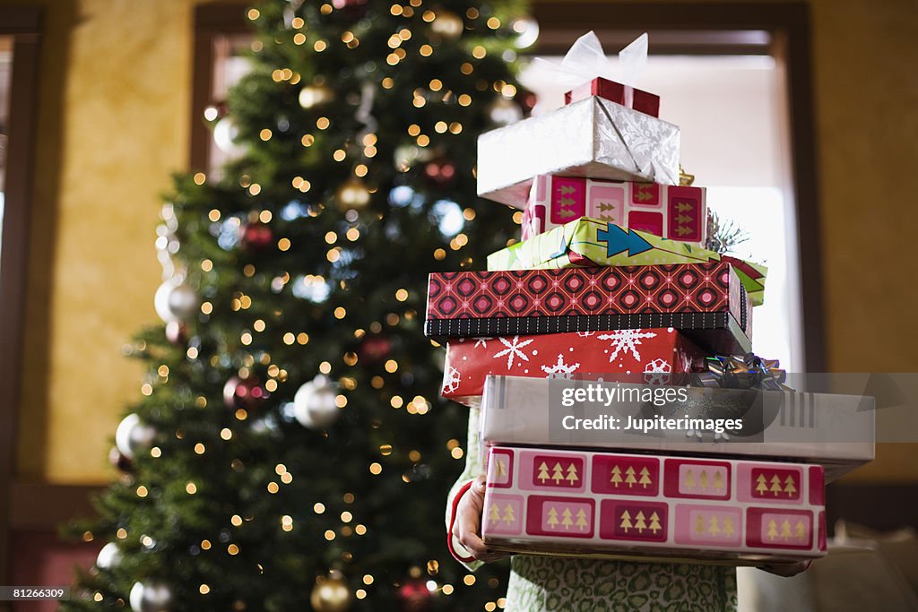 Child holding stack of Christmas gifts