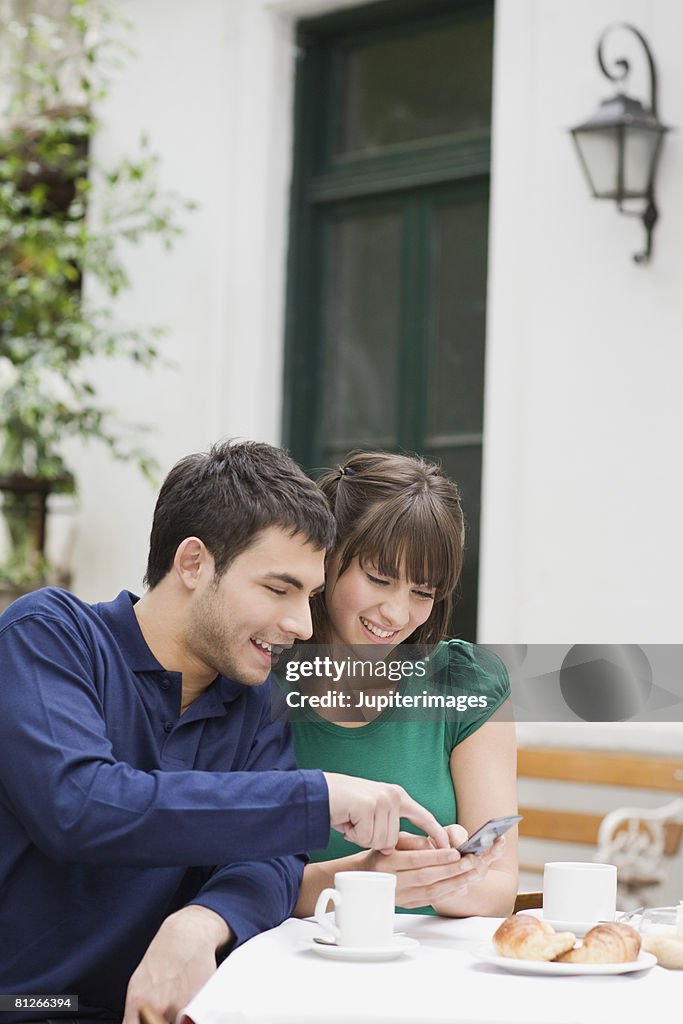 Couple with cell phone at cafe