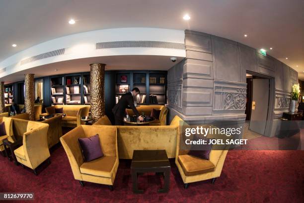 An employee works at the restaurant of the newly-renovated Barriere Le Fouquet's Hotel, on the Champs-Elysees avenue in Paris, on July 10, 2017. /...