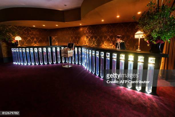 An employee works at the reception of the newly-renovated Barriere Le Fouquet's Hotel, on the Champs-Elysees avenue in Paris, on July 10, 2017. / AFP...