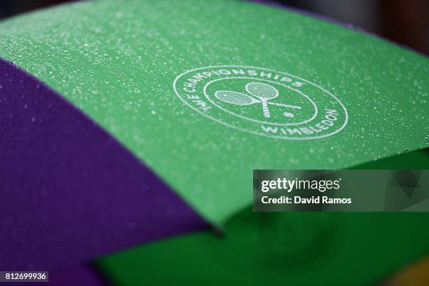 Rain drops are seen on a Wimbledon umbrella on day eight of the Wimbledon Lawn Tennis Championships at the All England Lawn Tennis and Croquet Club...