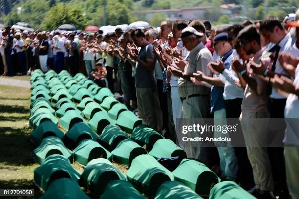 People pray after the funeral ceremony of newly identified 71 Srebrenica genocide victims, to mark the 22nd anniversary of the Srebrenica genocide,...