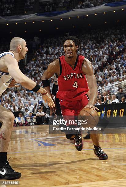 Chris Bosh of the Toronto Raptors drives to the basket against Marcin Gortat of the Orlando Magic in Game Two of the Eastern Conference Quarterfinals...