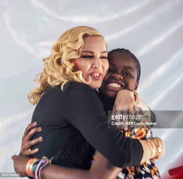 Pop star Madonna hugs her Malawian adopted daughter Mercy James after she made a speech during the opening ceremony of the Mercy James Children's...
