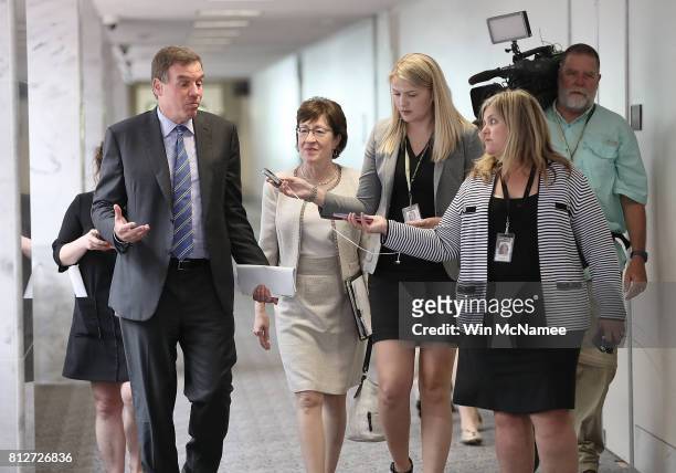 Sen. Mark Warner , ranking member of the Senate Select Committee on Intelligence, speaks with reporters while walking with Sen. Susan Collins before...