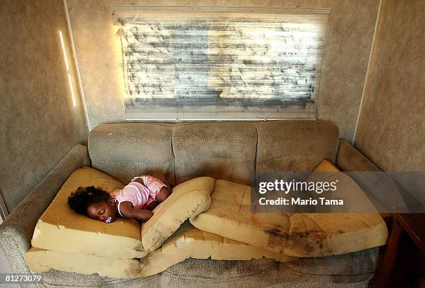Kailah Smith, 18 months, sleeps on a moldy couch caused by rain leaks in her parents' trailer in the FEMA Diamond trailer park just before the family...