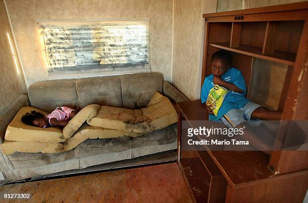 Kailah Smith, 18 months, sleeps on a moldy couch caused by rain leaks in her parents' trailer as Kimber Smith looks on just before the family moved...
