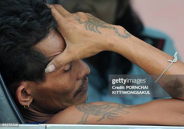 Thai private buse driver rests in a bus lined up in a street during a demonstration in Bangkok on May 29, 2008. Private bus companies parked some 200...