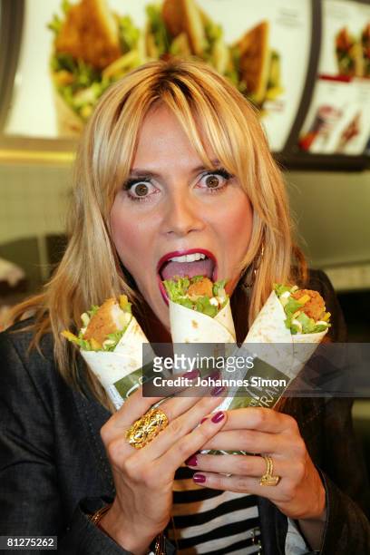 Super model Heidi Klum poses with three new designed McDonald's chicken wraps during a press conference at the Munich Inner City McDonald's...